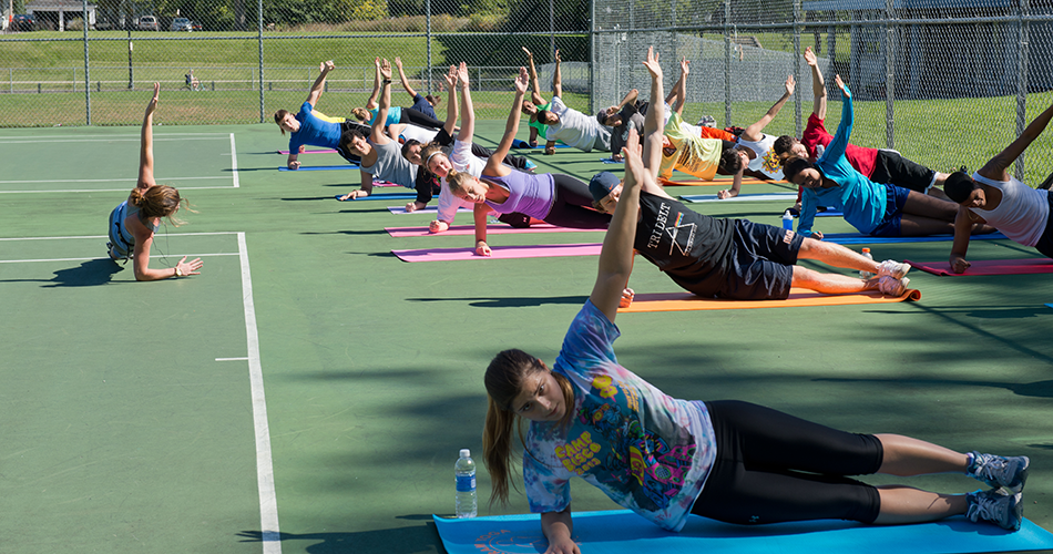 Students doing yoga on tennis courts