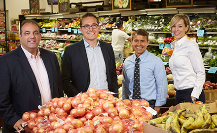 Local businessowners who contributed to a charity posing for a picture in a grocery store