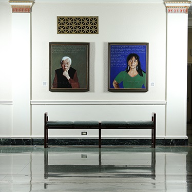 Two paintings hang on the wall in the Maxwell School foyer