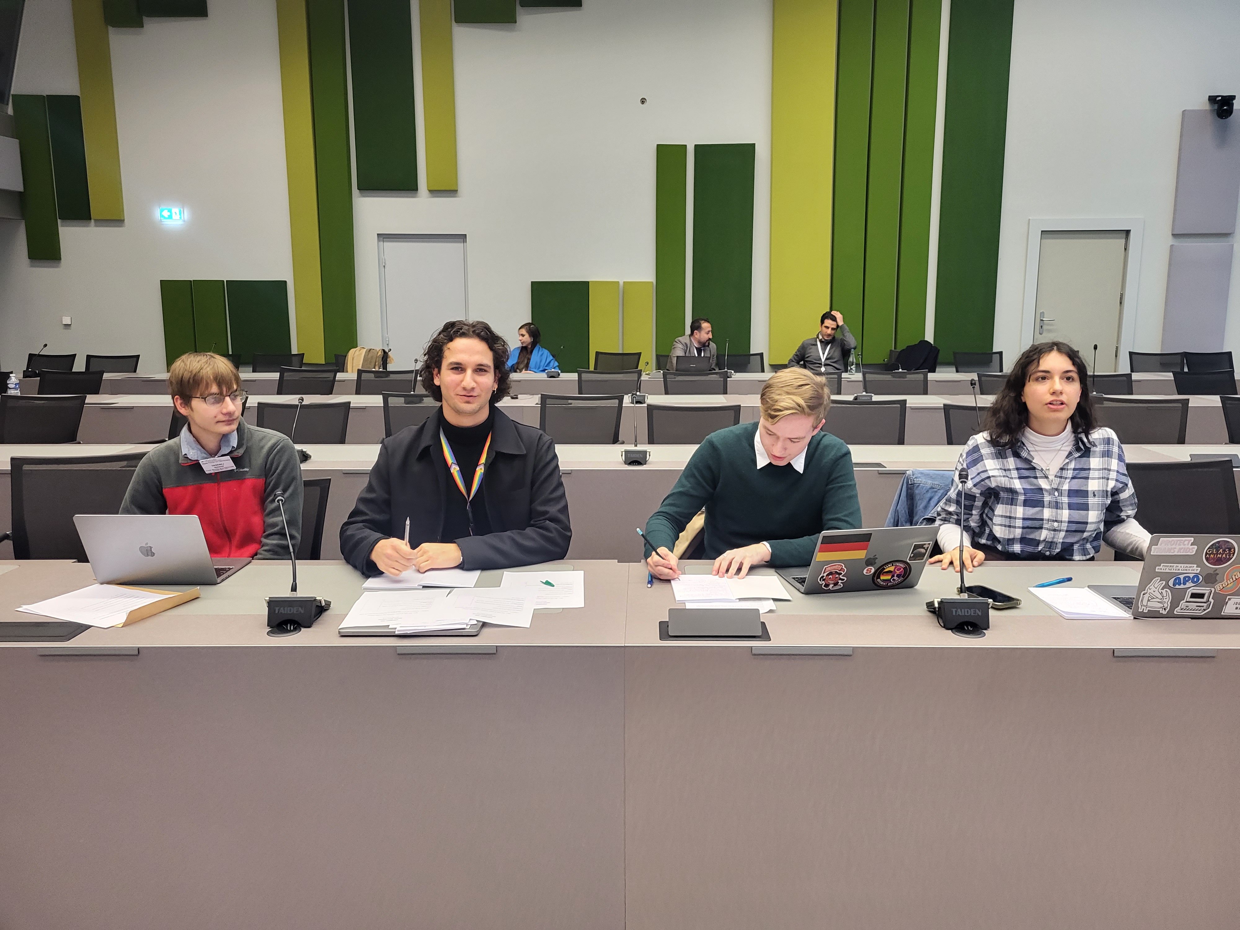 Four people seated at a long desk in the Council of Europe