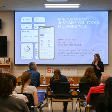Undergraduate student presenting in front of a panel of judges