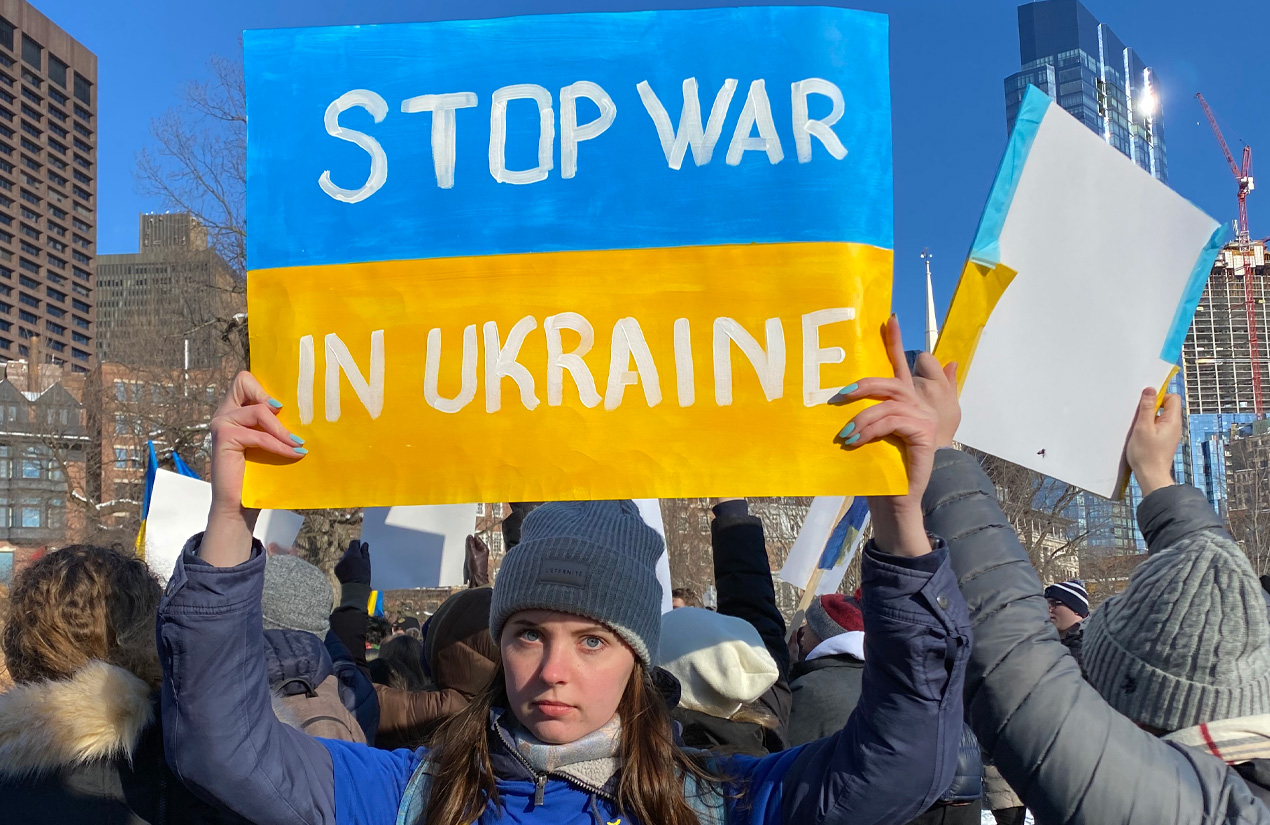 Student holding sign that says stop war in ukraine
