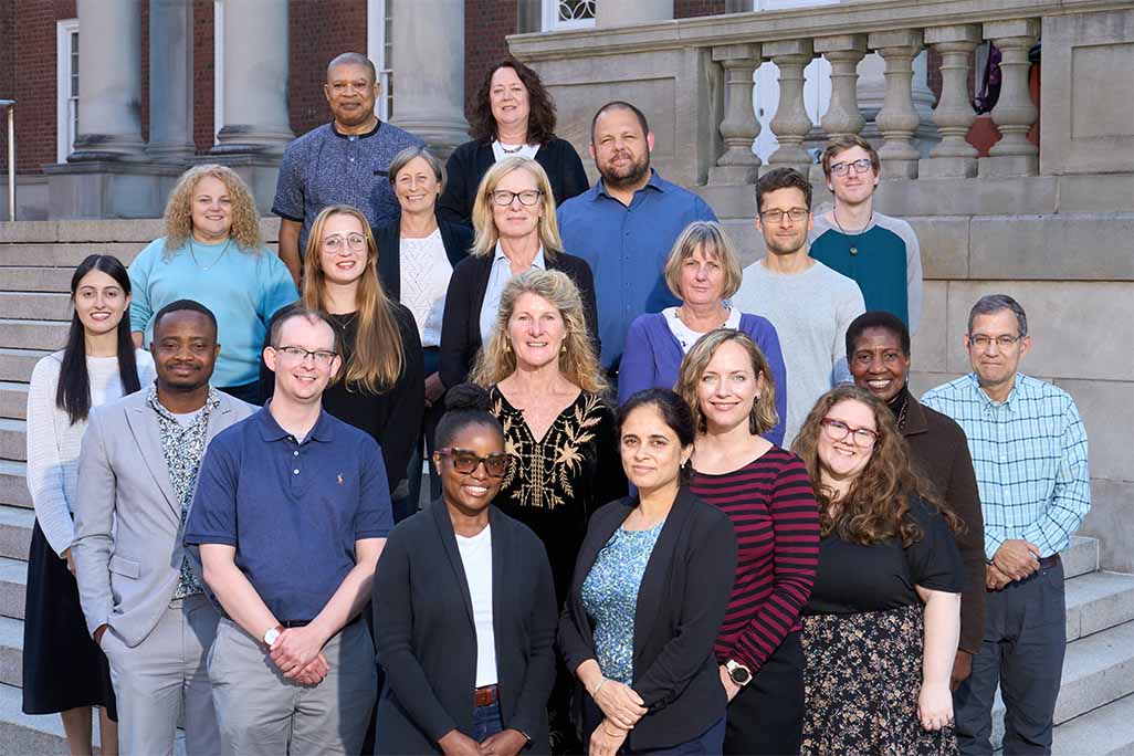Group photo of the public health department faculty posing for a photo on the Maxwell Hall steps