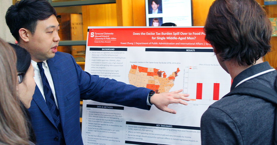 A student points to a poster presentation