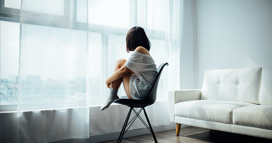Girl sitting in chair looking out window