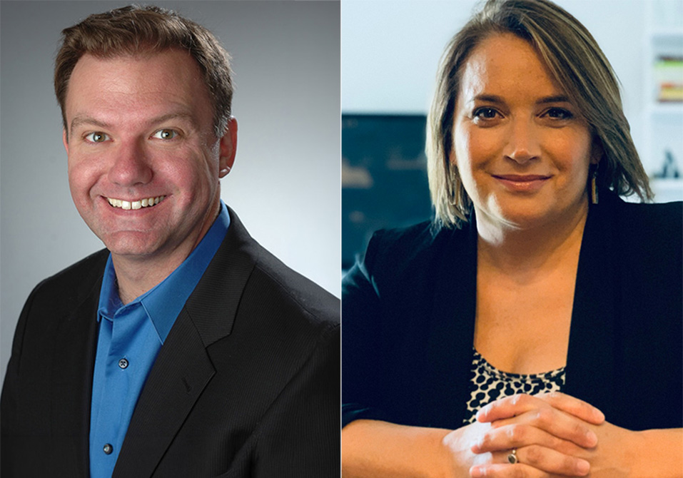 One person in a dark blazer and blue shirt, one person in a black blazer smiling.
