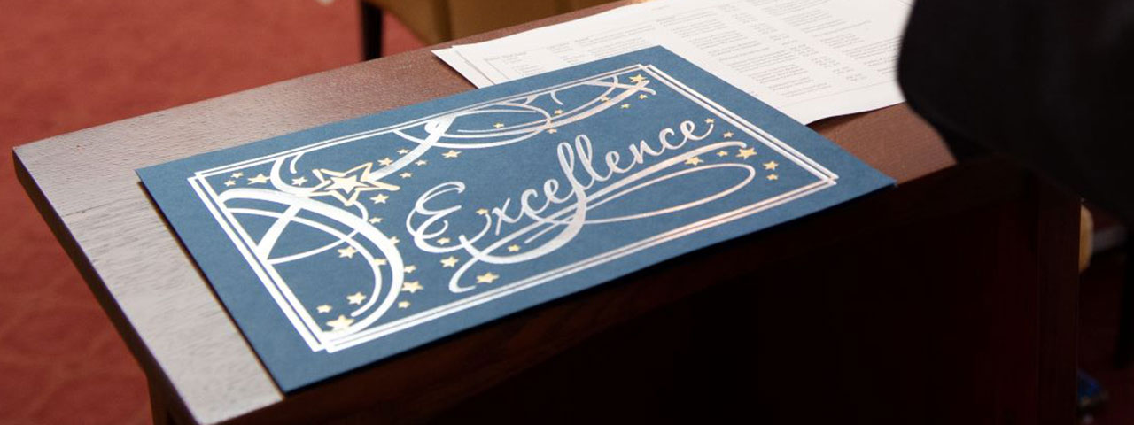Stylized presentation of the word Excellence on a table