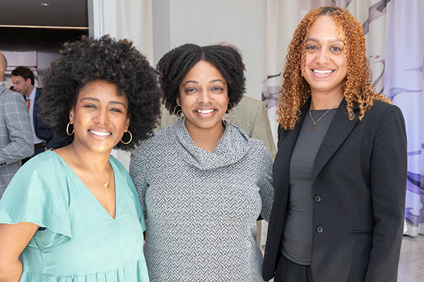 Three attendees smile together at the Maxwell School of Citizenship and Public Affairs Awards of Excellence event.