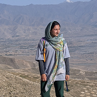 Woman standing in front of Afghanistan mountains