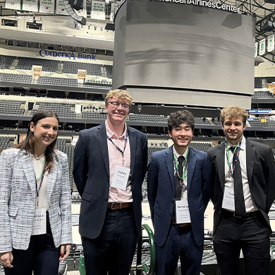 Four male students pose in a stadium