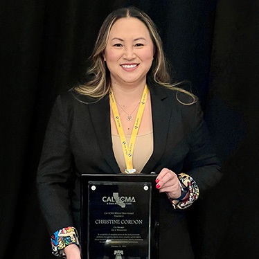 A person holding a Cal-ICMA Ethics Hero Award plaque at an awards ceremony.