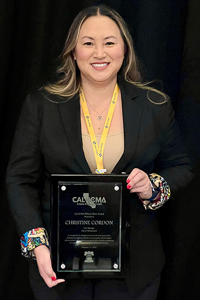 A person holding a Cal-ICMA Ethics Hero Award plaque at an awards ceremony.