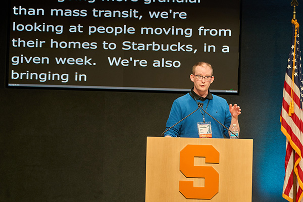 A person stands at a podium with a large