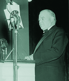 31st President, Herbert Hoover, standing at a lectern and preparing to speak