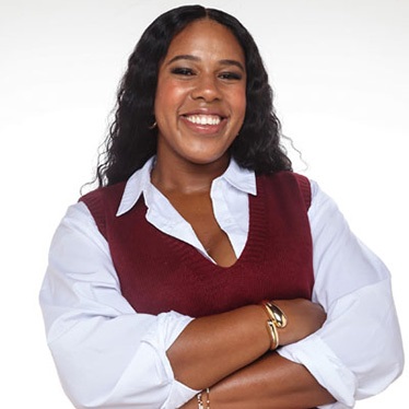 Person smiling, wearing a white shirt with a maroon vest, standing against a white background.