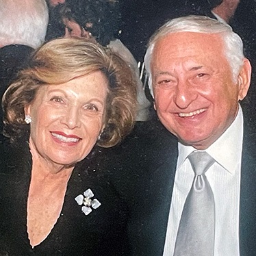 Photo of two people smiling at a formal event.