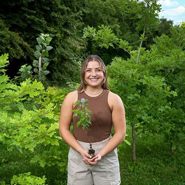 Portrait of student Naomi Weinflash holding a plant