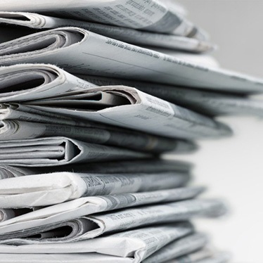 A stack of folded newspapers.