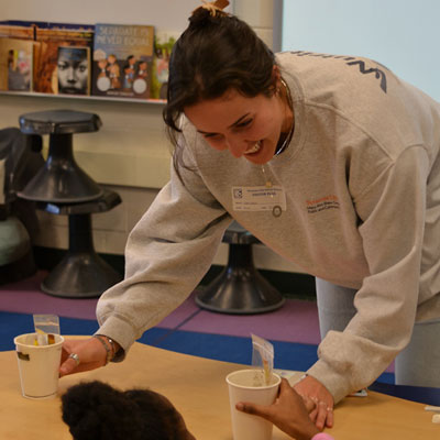 Tess Palin works with a young child at a table.