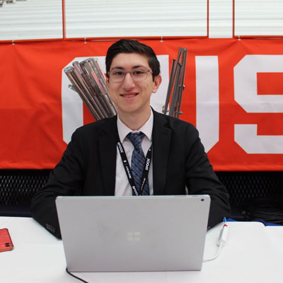 Matthew Penn sits behind a computer at an auction desk