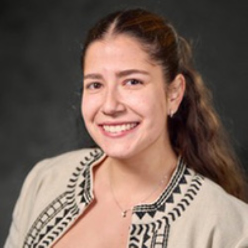 Portrait of a smiling person wearing a patterned top.
