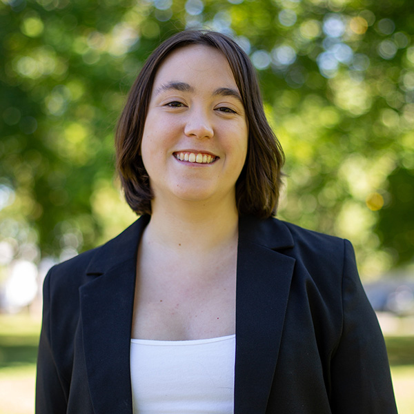 Young woman with shoulder length hair and dark suit jacket with white shirt