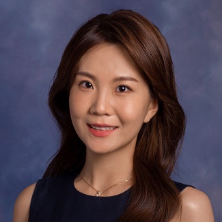 Professional photo of a smiling person with dark hair and a gold necklace