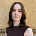 Photo of a person with brown hair wearing a brown top.