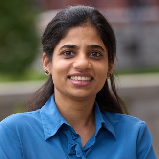 Portrait of a smiling person wearing a blue shirt, set against a softly blurred background.