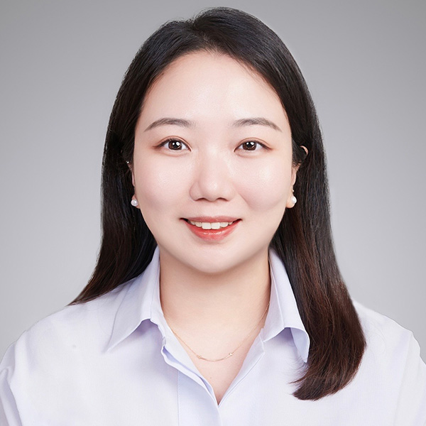 Professional headshot of a person wearing a light blue shirt against a gray background.
