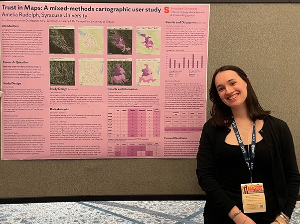 A person smiling beside a research poster titled "Trust in Maps: A mixed-methods cartographic study.